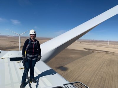 Woman wind technician on top of turbine