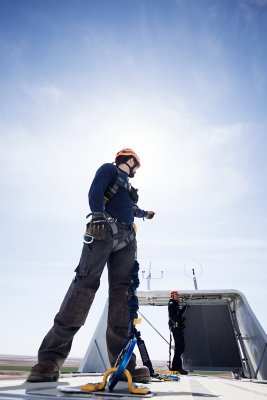 Technician on top of wind turbine