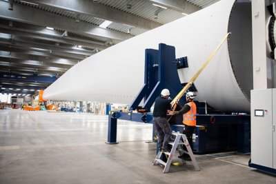Vestas employees perform final checks on a newly completed 15 megawatt V236 wind turbine blade at their factory in Nakskov, Denmark.
