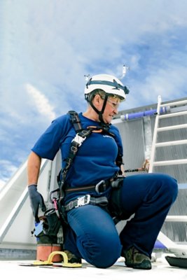 Female Service Technician on top of turbine